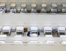 Personal médico prepara camas en un hospital improvisado en un centro de exposiciones para atender a enfermos de coronavirus. AP/Chinatopix