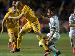 Jorge Torres Nilo (i), de Tigres, disputa el balón con Jose Madueña (d), de Chivas de Guadalajara, en el encuentro de este sábado. EFE/M. Sierra