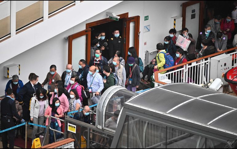 Pasajeros hacen fila para bajar del World Dream en la terminal de cruceros de Hong Kong. AFP/P. Fong