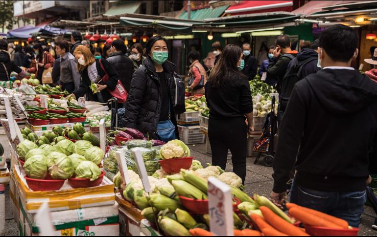 Habitantes usan hoy mascarillas en un mercado en Hong Kong como una medida para combatir la propagación del virus. AFP/D. De La Rey