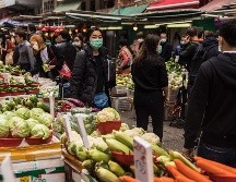 Habitantes usan hoy mascarillas en un mercado en Hong Kong como una medida para combatir la propagación del virus. AFP/D. De La Rey