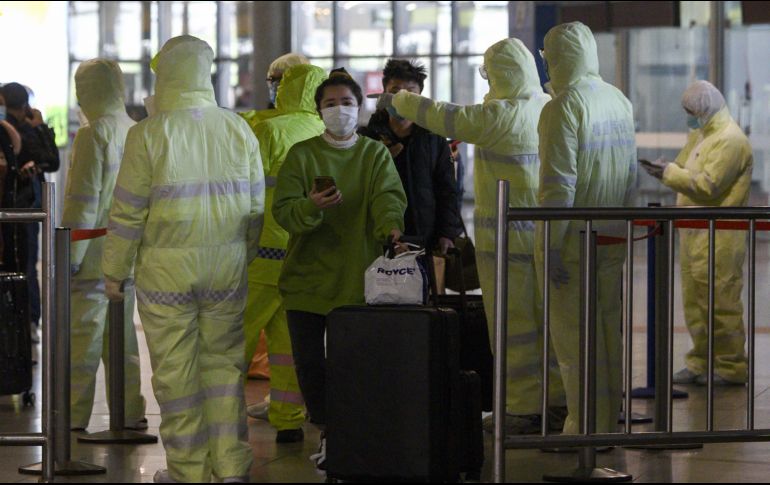 Trabajadores del sector salud revisan hoy el historial médico de viajeros en la estación de trenes de Shanghai, China. AFP/N. Celis