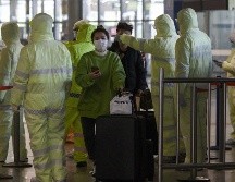 Trabajadores del sector salud revisan hoy el historial médico de viajeros en la estación de trenes de Shanghai, China. AFP/N. Celis