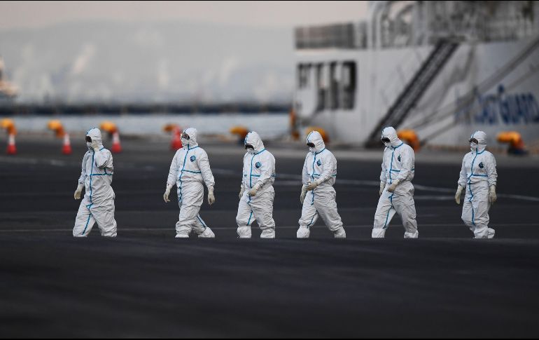 Personal con atuendos protectores se ve cerca del crucero Diamond Princess, en cuarentena en Yokohama, Japón. En el barco se han detectado 135 casos confirmados del coronavirus. AFP/C. Triballeau