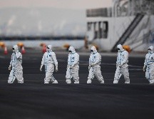 Personal con atuendos protectores se ve cerca del crucero Diamond Princess, en cuarentena en Yokohama, Japón. En el barco se han detectado 135 casos confirmados del coronavirus. AFP/C. Triballeau