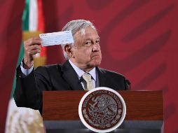 El Presidente muestra el cheque con la suma para pagar el sorteo mediante el que se prevé juntar recursos para equipar hospitales. EFE/S. Gutiérrez