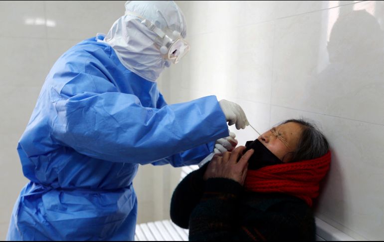 Un médico toma una muestra a una mujer en Yinan, China, para verificar si contrajo el coronavirus. AP/Chinatopix