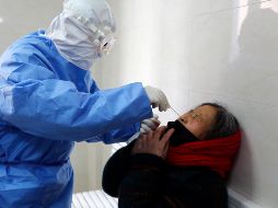 Un médico toma una muestra a una mujer en Yinan, China, para verificar si contrajo el coronavirus. AP/Chinatopix