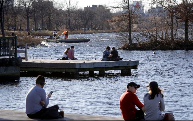 Fotografía del 12 de enero donde varias personas disfrutan de un día inusualmente cálido en la vera del río Charles, en Boston. AP/S. Saenne