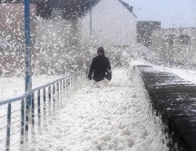 Una persona camina entre espuma de mar en Saint-Guenole, Francia, por los efectos de la tormenta. AFP/F. Tanneau