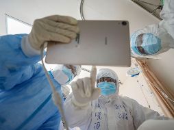 Médicos observan una imagen mientras revisan a un paciente con covid-19 en el hospital de la Cruz Roja de Wuhan, en la provincia de Hubei. AFP/ARCHIVO
