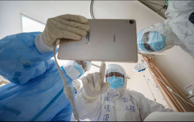 Médicos observan una imagen mientras revisan a un paciente con covid-19 en el hospital de la Cruz Roja de Wuhan, en la provincia de Hubei. AFP/ARCHIVO