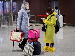 Pasajeros en el aeropuerto Daxing en Pekín usan protectores para evitar el contagio del nuevo coronavirus. AFP/N. Asfouri