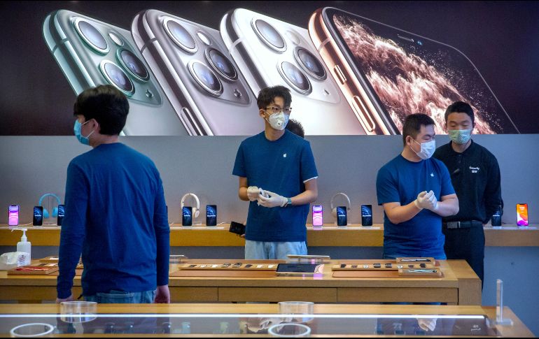 Empleados con mascarillas en la reapertura de una tienda Apple en la capital china. AP/M. Schiefelbein