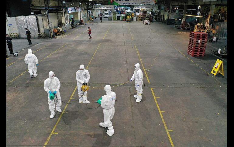 Trabajadores rocían hoy desinfectante en un centro de venta de productos agrícolas en Daegu. AP/Yonhap/Kim Hyun-tae