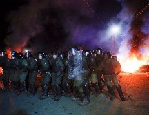 Policías antimotines se preparan para replegar a manifestantes. AP/E. Lukatsky