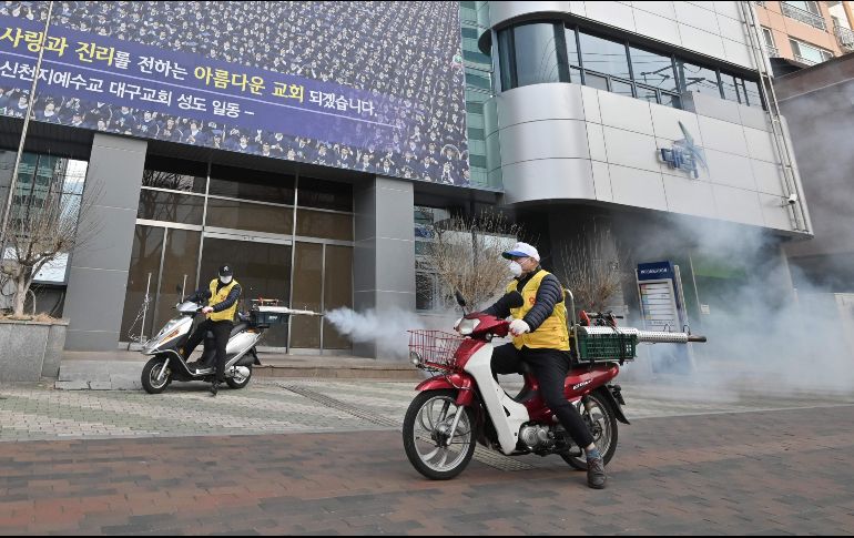 Personal de salud rocía desinfectante frente al templo Shincheonji en Daegu, Corea del Sur. AFP/Jung Yeon-je