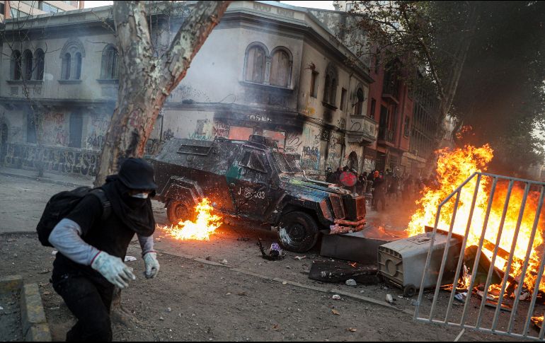 Manifestantes chocan con los antimotines en Santiago. AP/E. Félix