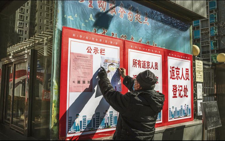 Prevención. Un hombre publica recomendaciones de higiene en un barrio de Beijing. AFP