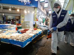 Empleados realizan labores preventivas de desinfección en un mercado de Seúl, la capital surcoreana. AFP/A. Young-joon