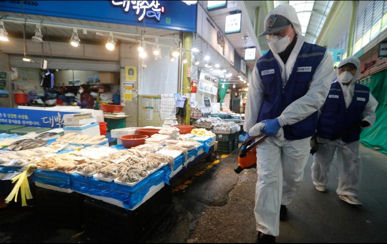 Empleados realizan labores preventivas de desinfección en un mercado de Seúl, la capital surcoreana. AFP/A. Young-joon