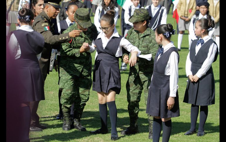 Militares auxilian a una alumna afectada por insolación durante la ceremonia conmemorativa por el Día de la Bandera en Campo Marte. NTX/R. Solís