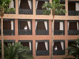 Huéspedes se asoman desde balcones del hotel puesto en cuarentena, situado en el municipio de Adeje, en Tenerife. AP
