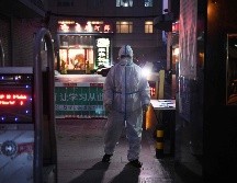 Un guardia de seguridad usa atuendo protector en la entrada de un restaurante este martes en Pekín, como medida para prevenir el covid-19. AFP/G. Baker