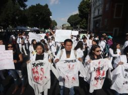Los estudiantes marcharon portando batas blancas manchadas de rojo con los nombres de los tres jóvenes asesinados. SUN / O. Contreras