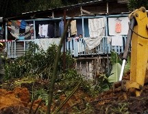 Un niño observa desde su casa la labor de los socorristas este miércoles luego del deslizamiento de tierra ocasionado por un fuerte aguacero en Chinchiná. EFE