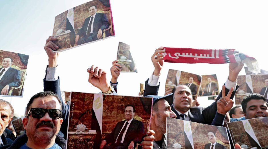 Miles de personas acudieron al funeral y levantaron fotografías de Mubarak. AFP/M. el-Shahed