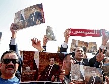 Miles de personas acudieron al funeral y levantaron fotografías de Mubarak. AFP/M. el-Shahed