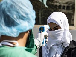 Un filtro de revisión de temperatura a una pasajera de autobús en Siria, tras cruzar la frontera en Semalka desde Iraq. AFP/D. Souleiman