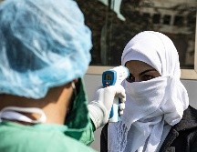 Un filtro de revisión de temperatura a una pasajera de autobús en Siria, tras cruzar la frontera en Semalka desde Iraq. AFP/D. Souleiman