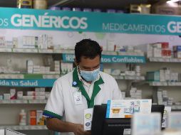 Un empleado de una farmacia atiende a los clientes protegido con un cubrebocas en la Ciudad de México. EFE/S. Gutiérrez