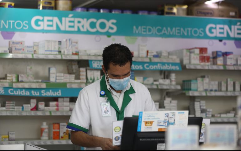 Un empleado de una farmacia atiende a los clientes protegido con un cubrebocas en la Ciudad de México. EFE/S. Gutiérrez