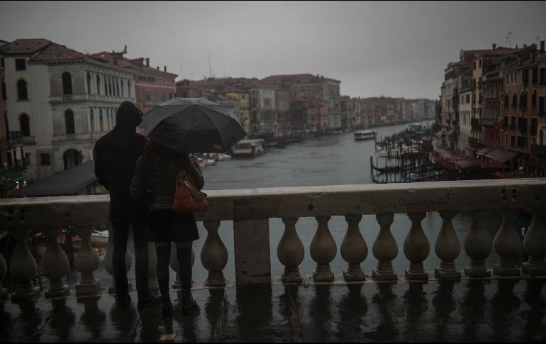 Una pareja se ve hoy en el puente Rialto en Venecia. El coronavirus está impactando en el turismo. AP/F. Seco
