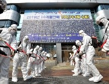 Soldados en atuendos protectores rocían desinfectante como medida contra el contagio de coronavirus frente al templo Shincheonji en Daegu, Corea del Sur. AP/Newsis/Lee Moo-ryul