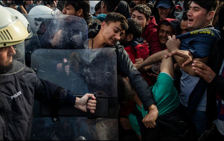 Migrantes se enfrentan hoy con antimotines griegos en la isla de Lesbos. AFP/A. Tzortzinis