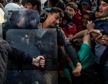 Migrantes se enfrentan hoy con antimotines griegos en la isla de Lesbos. AFP/A. Tzortzinis
