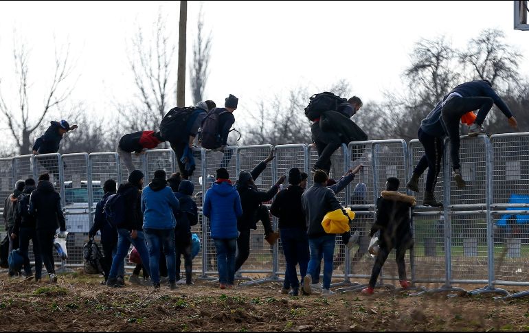Migrantes trepan una cerca instalada por autoridades turcas cerca de la frontera con Grecia. AP/E. Gurel