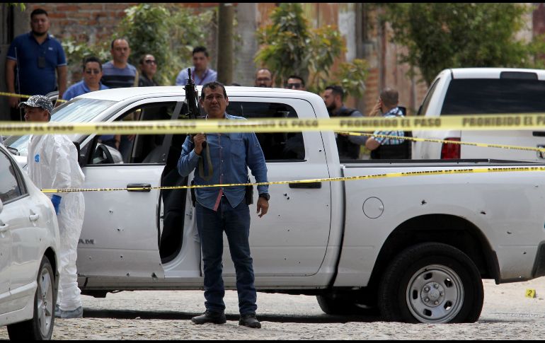 Policías y forenses en la zona del tiroteo en Las Huertas. AFP/U. Ruiz