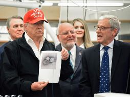 Donald Trump con una foto del coronavirus en los Centros para el Control y la Prevención de Enfermedades. AP/H. Shin