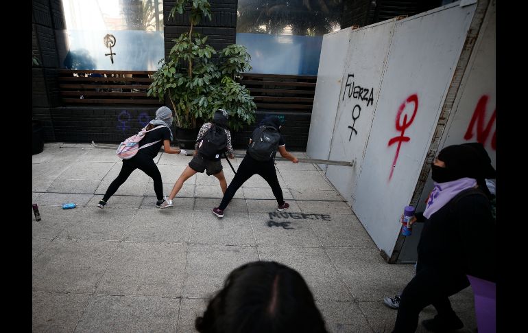 Manifestantes arremeten contra una vallas en un edificio. AP/R. Blackwell