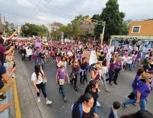 A las orillas hay mujeres con carteles que no se unen pero que con puño en alto y con consignas muestran su unión al contingente. EL INFORMADOR / E. Barrera