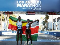 Festejo. Los ganadores celebran con sus respectivas banderas en la línea de meta. AFP