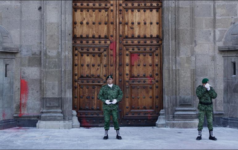 la puerta principal de Palacio Nacional luce con manchas de pintura roja lanzadas ayer durante la masiva movilización. NTX / A. Guzmán