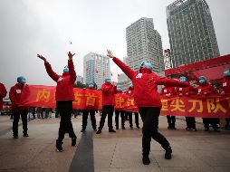 Trabajadores de un hospital temporal para pacientes con Covid-19 en Wuhan, China, celebran la baja en el número de pacientes en esa ciudad. EFE / EPA / LI KE