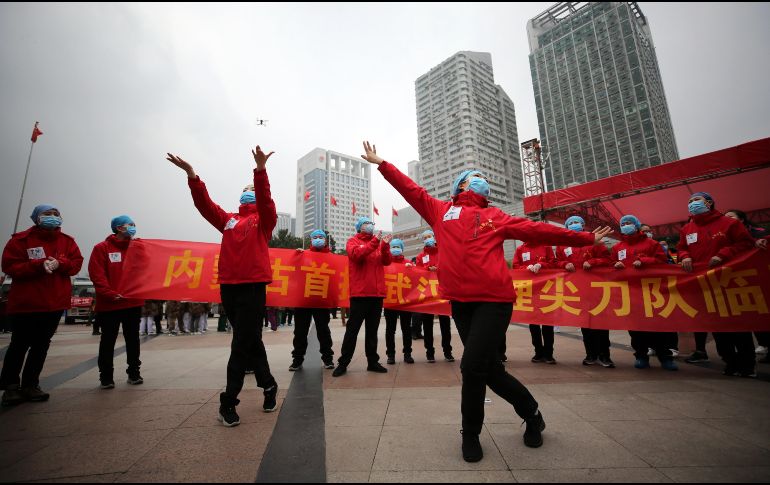 Trabajadores de un hospital temporal para pacientes con Covid-19 en Wuhan, China, celebran la baja en el número de pacientes en esa ciudad. EFE / EPA / LI KE