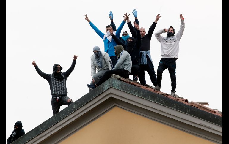 Internos se manifiestan desde el techo de la cárcel San Vittore, en Milán. AP/A. Calanni